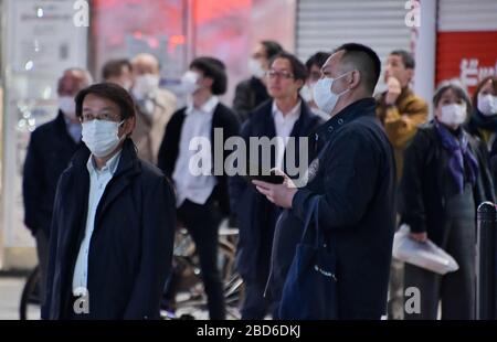 Tokyo, Giappone. 7 aprile 2020. I pedoni osservano la segnaletica digitale che ha esposto la conferenza stampa del primo ministro Shinzo Abe, vicino alla stazione di Shinjuku a Tokyo, Giappone, martedì 7 aprile 2020. Foto di Keizo Mori/UPI Credit: UPI/Alamy Live News Foto Stock