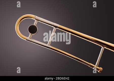 Parte del cursore di sintonizzazione di un trombone con sfondo grigio sfumato. Vista laterale. Composizione orizzontale. Foto Stock