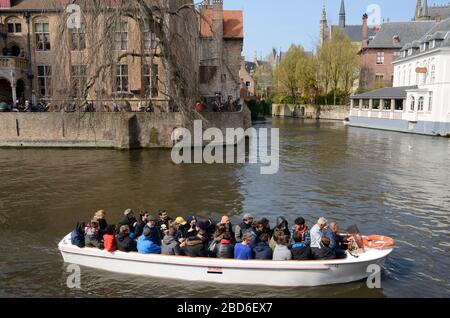 Brugge, Belgio - 31 marzo 2019: Persone in barca turistica al canale di Dijver nella città vecchia di Brugge, Belgio. Foto Stock