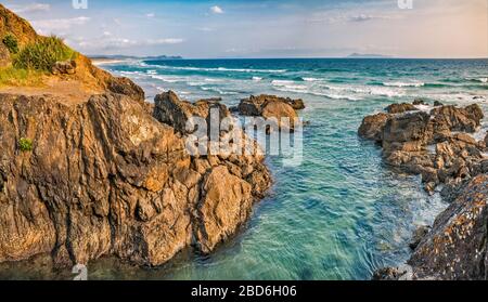 Scogliere a te Arai Point all'alba, Auckland Region, North Island, Nuova Zelanda Foto Stock