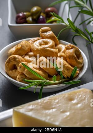 Biscotti taralli con formaggio Asiago e olive. Foto Stock