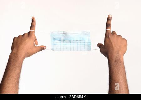 Corto di uomo nero che tiene maschera facciale Foto Stock