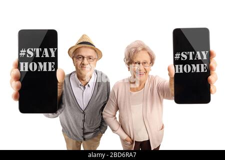 Gli anziani che tengono i telefoni con i messaggi che dicono rimanere a casa a causa di covid-19 pandemic isolato su sfondo bianco Foto Stock