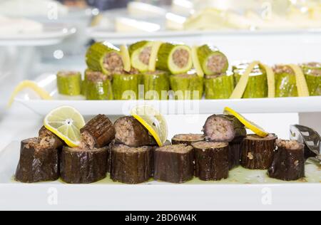 Melanzane saporite farcite con riso, zucchine sfocate farcite con riso, fette di formaggio sullo sfondo. Cibo su piatti bianchi concetto. Cucina turca eggpl Foto Stock