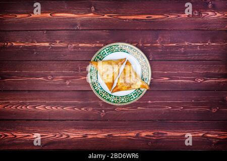 Piatto con deliziosi samosas o samsa su sfondo di legno. Vista dall'alto Foto Stock