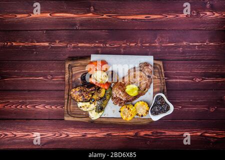 Deliziosa bistecca alla griglia con verdure arrosto assortite e mais con salsa. Vista dall'alto Foto Stock