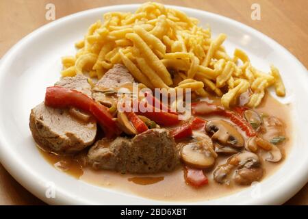 filetto di maiale con spaetzle, champignons e paprika Foto Stock