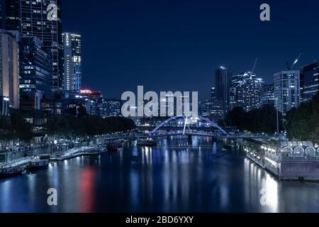 Melbourne Australia - Marzo 9 2020; la città di notte, edifici, luci e riflessi, in tonalità blu con colore rosso spot. Foto Stock