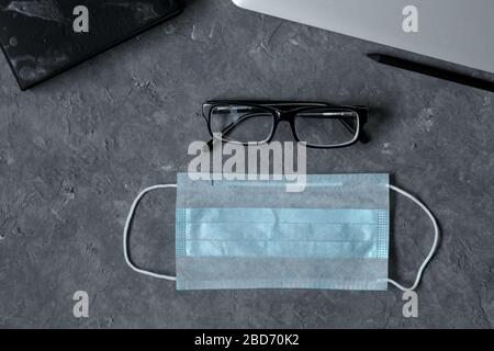 Lavoro da casa. Tastiera, telefono, maschera medica protettiva, antisettico sul tavolo. Il concetto di lavoro a distanza durante la quarantena coronavirus, spazio di copia. Foto Stock