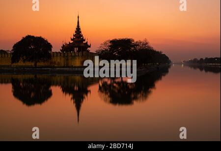 Tramonto con cielo colorato di una delle quattro torri di avvistamento del complesso del palazzo, Mandalay, Myanmar Foto Stock