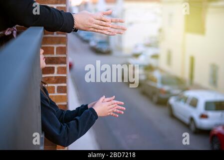mani applantate su un balcone che si affaccia su una strada con le luci accese Foto Stock