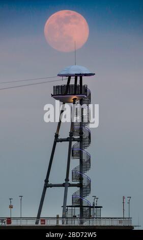 Bournemouth, Regno Unito. 7 aprile 2020. La Super Pink Moon sorge sopra il molo di Bournemouth a Dorset. Credit: Richard Crease/Alamy Live News Foto Stock