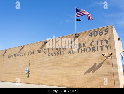 Esterno del Kingsbridge Bus Depot di Manhattan, appartenente alla New York City Transit Authority. Una bandiera americana ondeggia sopra l'edificio Foto Stock