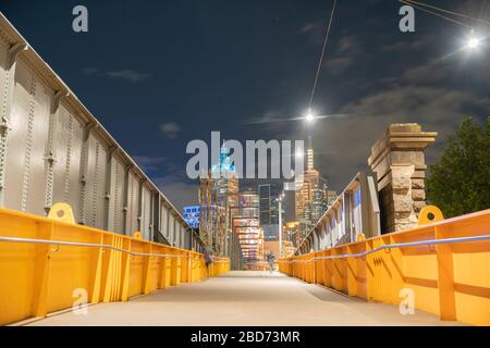 Melbourne Australia - Marzo 14 2020; scena notturna su e attraverso gli edifici del Sandridge Pedestrian Bridge e luci con luci di persone in movimento a lungo ex Foto Stock