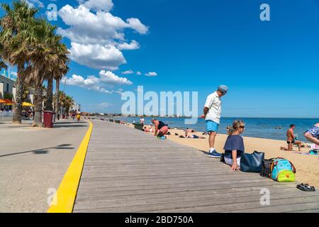 Melbourne Australia - Marzo 11 2020; Promenade lungo la spiaggia di St Kilda con gente fuori godendo l'estate e la spiaggia. Foto Stock