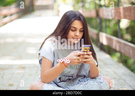 Donna scettica che testurisce. Closeup ritratto sconvolto infelice donna seria che parla di messaggi al telefono dispiaciuti con la conversazione isolato su un ponte legnoso Foto Stock