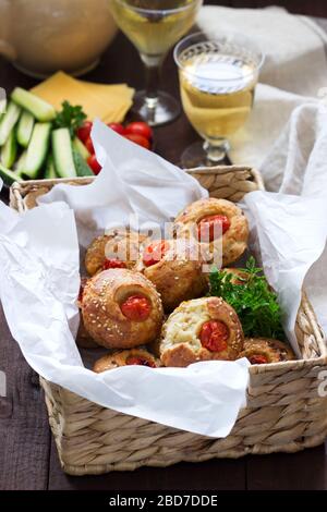 Muffin con formaggio, formaggio casolare e pomodori, verdure e formaggi serviti con vino. Foto Stock