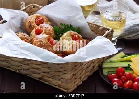 Muffin con formaggio, formaggio casolare e pomodori, verdure e formaggi serviti con vino. Foto Stock