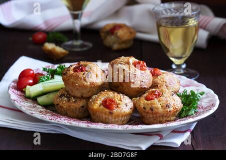 Muffin con formaggio, formaggio casolare e pomodori, verdure e formaggi serviti con vino. Foto Stock
