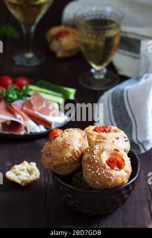 Muffin con formaggio, formaggio casolare e pomodori, verdure e formaggi serviti con vino. Foto Stock