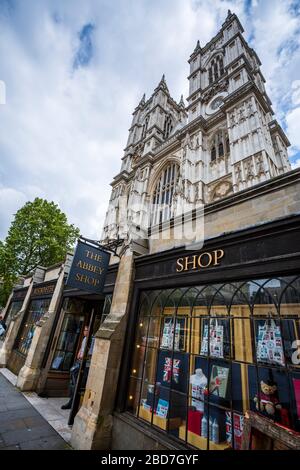 La magnifica Abbazia di Westminster e il negozio Abbey in primo piano in una mattina nuvolosa d'estate. Foto Stock