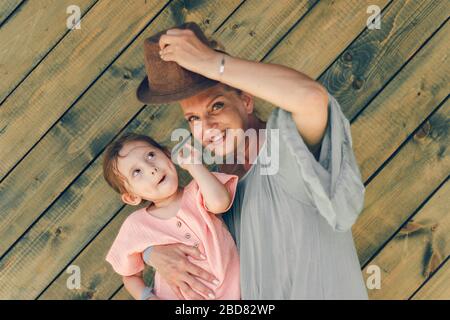 Emozione ritratto nonna e sua nipote in stile rurale cloathers su sfondo di legno verde. Concezione familiare. Foto Stock