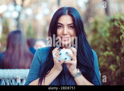 Cafe lo stile di vita della città. Donna indiana seduti in balcone terrazza di una fantasia nella caffetteria ristorante bicchiere di contenimento della bevanda calda tè. Raffreddare la modalità giovani Foto Stock