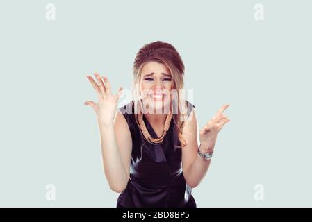 Frustrato. Primo piano donna molto arrabbiata urlando in orrore, grimace ritratto. Giovane donna stressata che ha rottura nervosa isolato retro verde chiaro Foto Stock