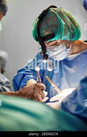 Il team di un chirurgo in uniforme esegue un'operazione su un paziente nella clinica del centro. Foto Stock