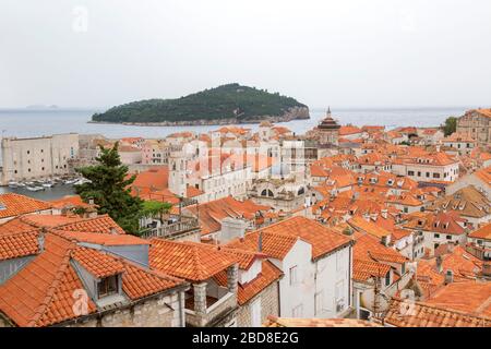 Tetti della città vecchia di Dubrovnik, dalla passeggiata delle mura della città, con l'isola di Lokrum sullo sfondo. Foto Stock