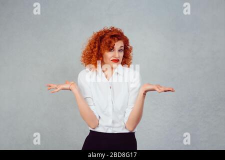 Non ne ho idea. Ritratto muto guardando donna braccia fuori si restringe spalle che si preoccupa in modo che cosa non so isolato su sfondo muro grigio. Umano negativo Foto Stock