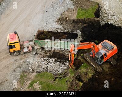 Colpo aereo di terra veicolo di riempimento scarico in cantiere Foto Stock