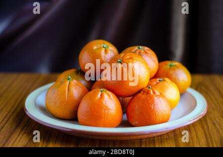 Frutta fresca di mandarino su un piatto in un colpo fermo di vita. Foto Stock