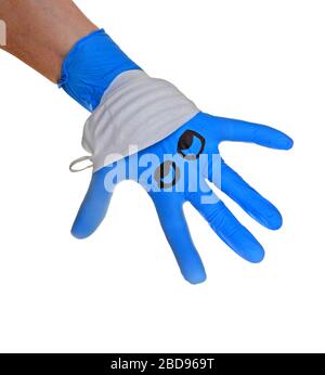 Mano con guanto chirurgico Blue con una maschera facciale raffigurante un viso con riferimento alla protezione medica contro il virus corona , covid 19. Foto Stock