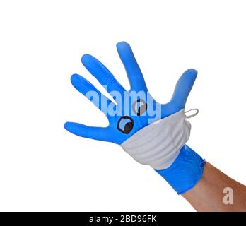 Mano con guanto chirurgico Blue con una maschera facciale raffigurante un viso con riferimento alla protezione medica contro il virus corona , covid 19. Foto Stock