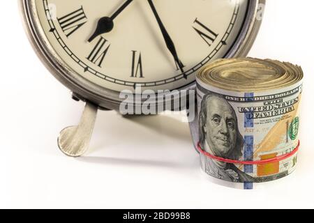 Denaro americano seduto vicino al desktop orologio. Il tempo è denaro o concetto di pianificazione finanziaria. Foto Stock