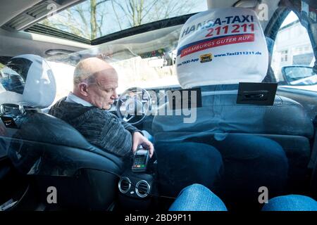 Amburgo, Germania. 7 aprile 2020. ILLUSTRAZIONE - Werner Möllmann, imprenditore di taxi, serve un cliente attraverso una finestra trasparente. Per proteggere i tassisti e i loro passeggeri, sempre più taxi ad Amburgo sono dotati di divisori tra la zona del conducente e il sedile posteriore. (Al dpa 'l'industria dei taxi equipaggia i veicoli con pareti divisorie per la protezione della corona') Credit: Daniel Bockwoldt/dpa/Alamy Live News Foto Stock