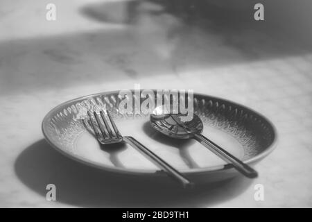 Un piatto vuoto in un ristorante chiuso mostra la solitudine, la crisi economica, la fame e la depressione come conseguenza di divaricarsi, bloccare e sé Foto Stock