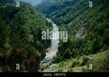 Il ponte sul fiume Tara in Montenegro e il ponte che collega le due rive del canyon. Un letto di pietra di un fiume pulito che scorre attraverso la val Foto Stock