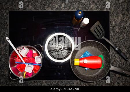 Concetto di inquinamento alimentare con rifiuti di plastica. Vista dall'alto di una stufa con frittura e una pentola ripiena di oggetti di plastica che rappresentano il cibo. Foto Stock