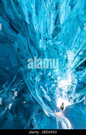 L'uomo si trova in una grotta di ghiaccio di Breidamerkurjokull, Austurland, Islanda, Europa del Nord Foto Stock