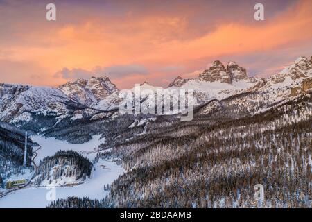 Cielo rosa al tramonto sulle tre Cime di Lavaredo e boschi innevati, vista aerea, Misurina, Dolomiti, provincia di Belluno, Veneto, Italia Foto Stock