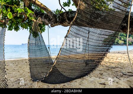 Blocco Covid-19. Amaca vuota pende dall'albero sulla spiaggia deserta sull'isola di Ko Yao noi a Phang-Nga Bay vicino a Phuket, Thailandia Foto Stock