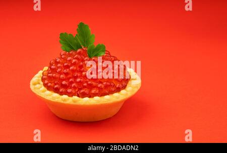 Tartletto con caviale rosso isolato su fondo rosso Foto Stock