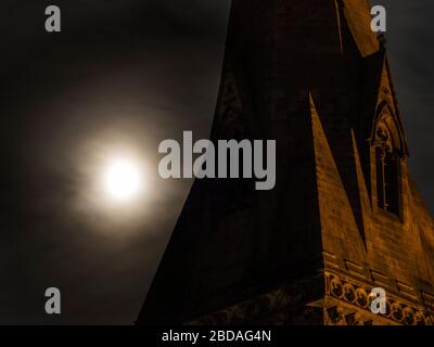 Inghilterra North Yorkshire Knaresborough luna rosa piena dietro nuvola di luce alla chiesa della Santissima Trinità guglia Martedì 7 Aprile 2020 Foto Stock