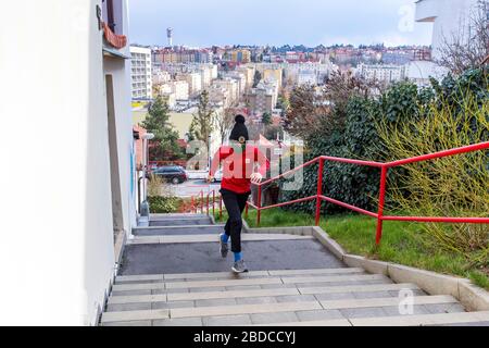 ragazzo che corre al piano superiore con maschera chirurgica fatta in casa Foto Stock