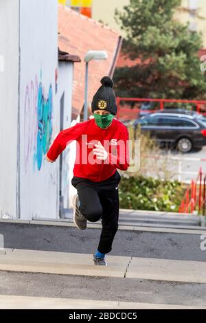 ragazzo che corre al piano superiore con maschera chirurgica fatta in casa Foto Stock