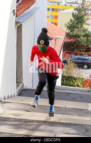 ragazzo che corre al piano superiore con maschera chirurgica fatta in casa Foto Stock