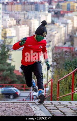 ragazzo che corre al piano superiore con maschera chirurgica fatta in casa Foto Stock