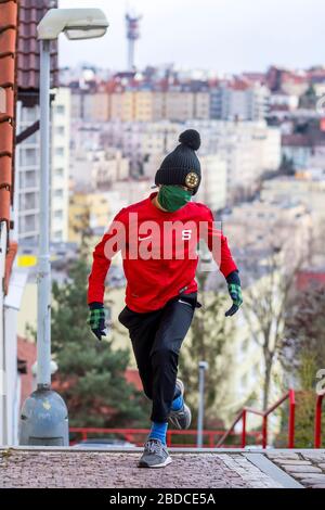 ragazzo che corre al piano superiore con maschera chirurgica fatta in casa Foto Stock